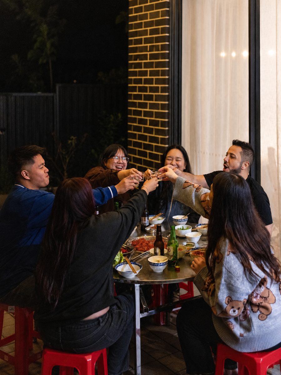 A group raising a toast across the table at night